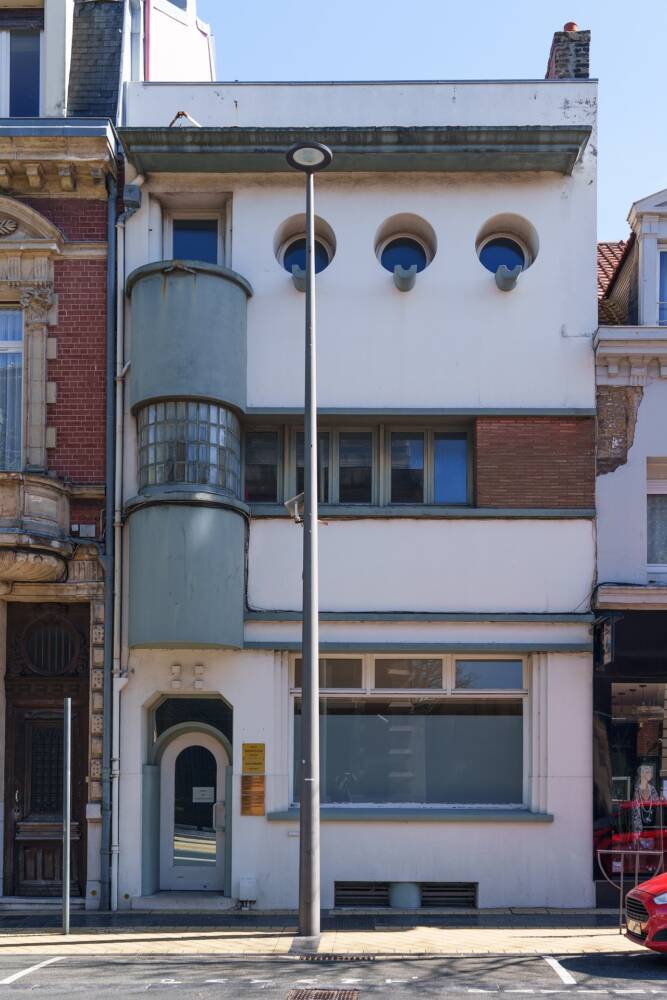 Maison de style Art Déco en briques rouges, et balcon en verre qui était autrefois de le siège de l'ancien automobile club.