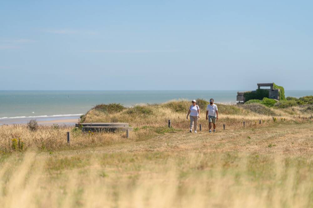 Deux randonneurs sur le littoral de la Côte d'Opale avec la mer en arrière plan.