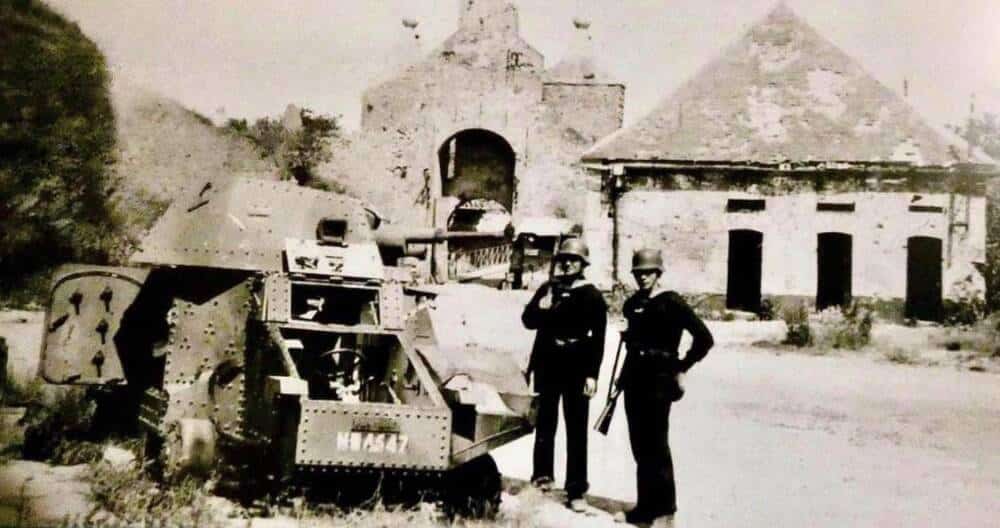 Photo d'archive en noir et blanc illustrant 2 militaires allemands s'étant emparés de la Citadelle de Calais en mai 1940 aux côtés d'un véhicule blindé.