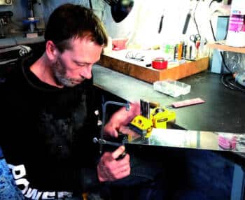 Portrait de Franck Ackermann dans son atelier travaillant sur la réalisation d'un couteau