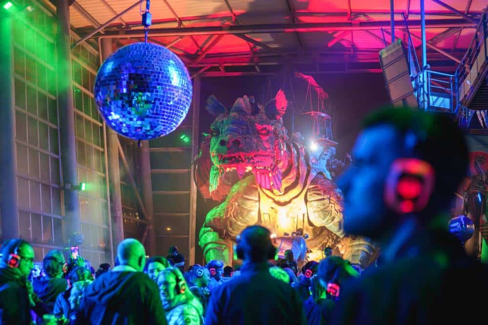 Luisteraars met koptelefoons aan de voet van de Dragon de Calais om te vibreren op het ritme van de 3 DJ's die in verbazingwekkende stilte mixen!