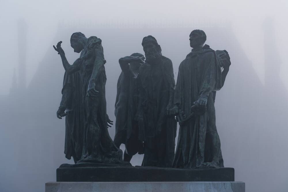 Le Monument aux Bourgeois de Calais érigé devant l'Hôtel de Ville de Calais, dans un brouillard dense.
