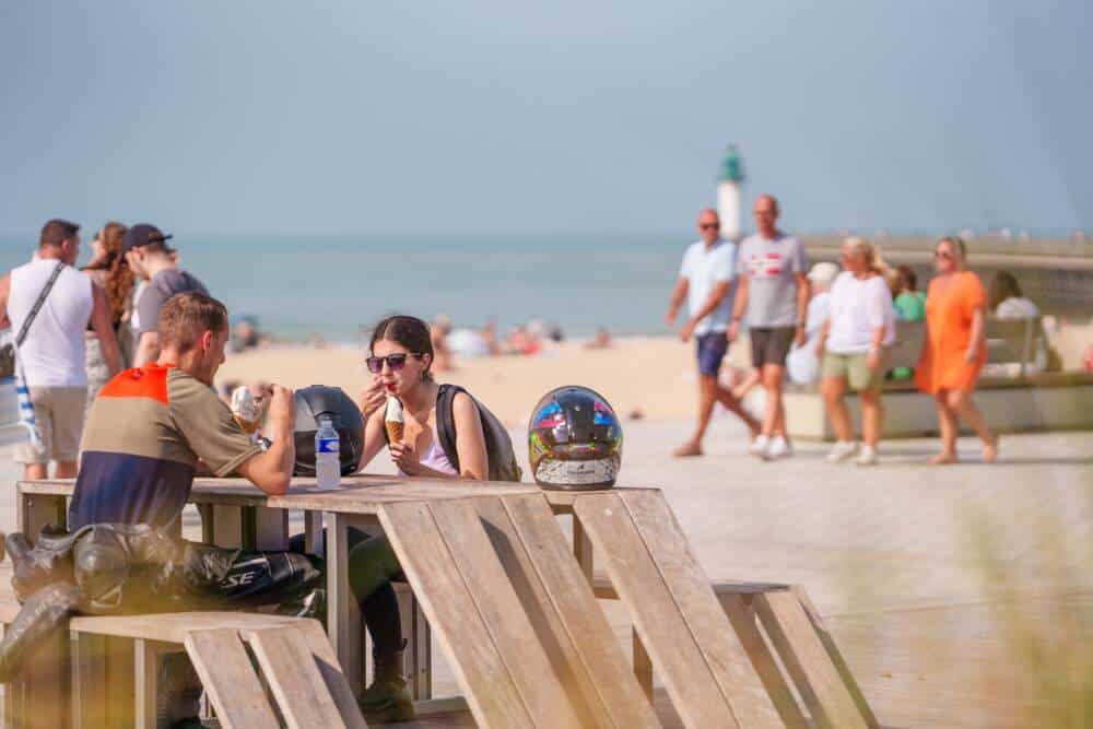 Cette photo montre des touristes se promenant le long de la digue Calais La Plage à proximité du village gourmand