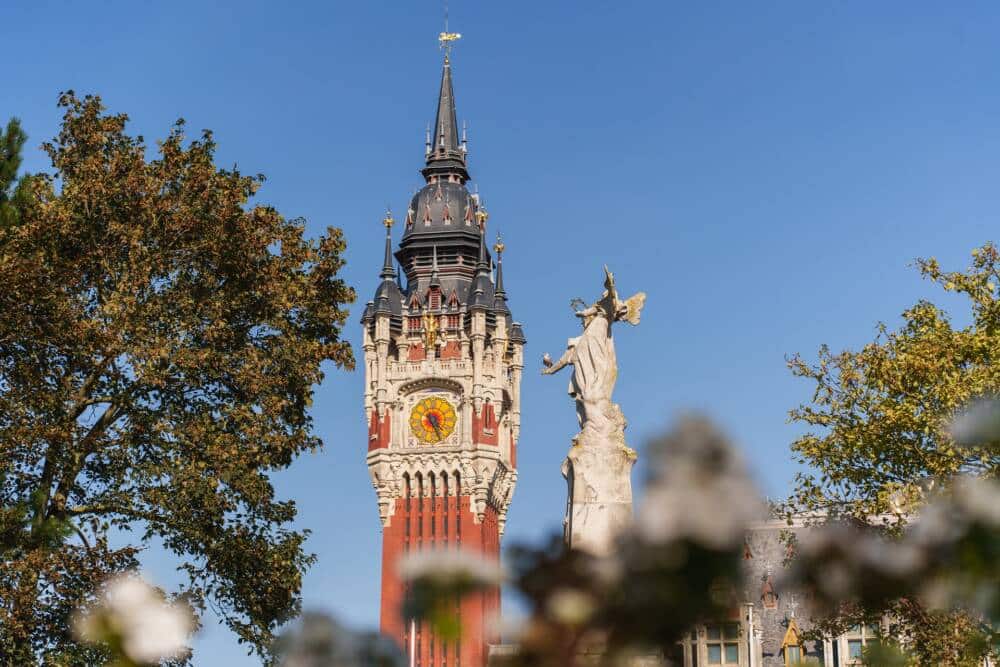 Vue de l'Hôtel de ville de Calais depuis le Parc Saint-Pierre avec le Monument aux enfants du Calaisis au premier plan.