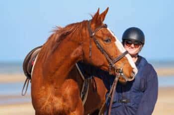 Portait de Constance et son cheval Gatsby sur la plage.