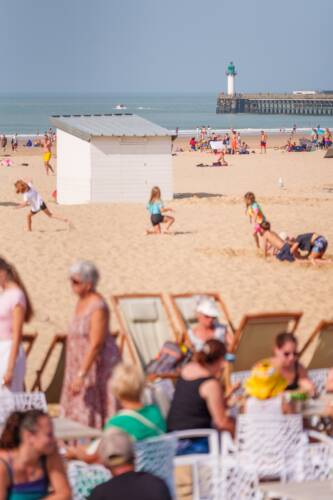 La plage de calais, ses chalets, tarasses et la jetée en arrière plan.