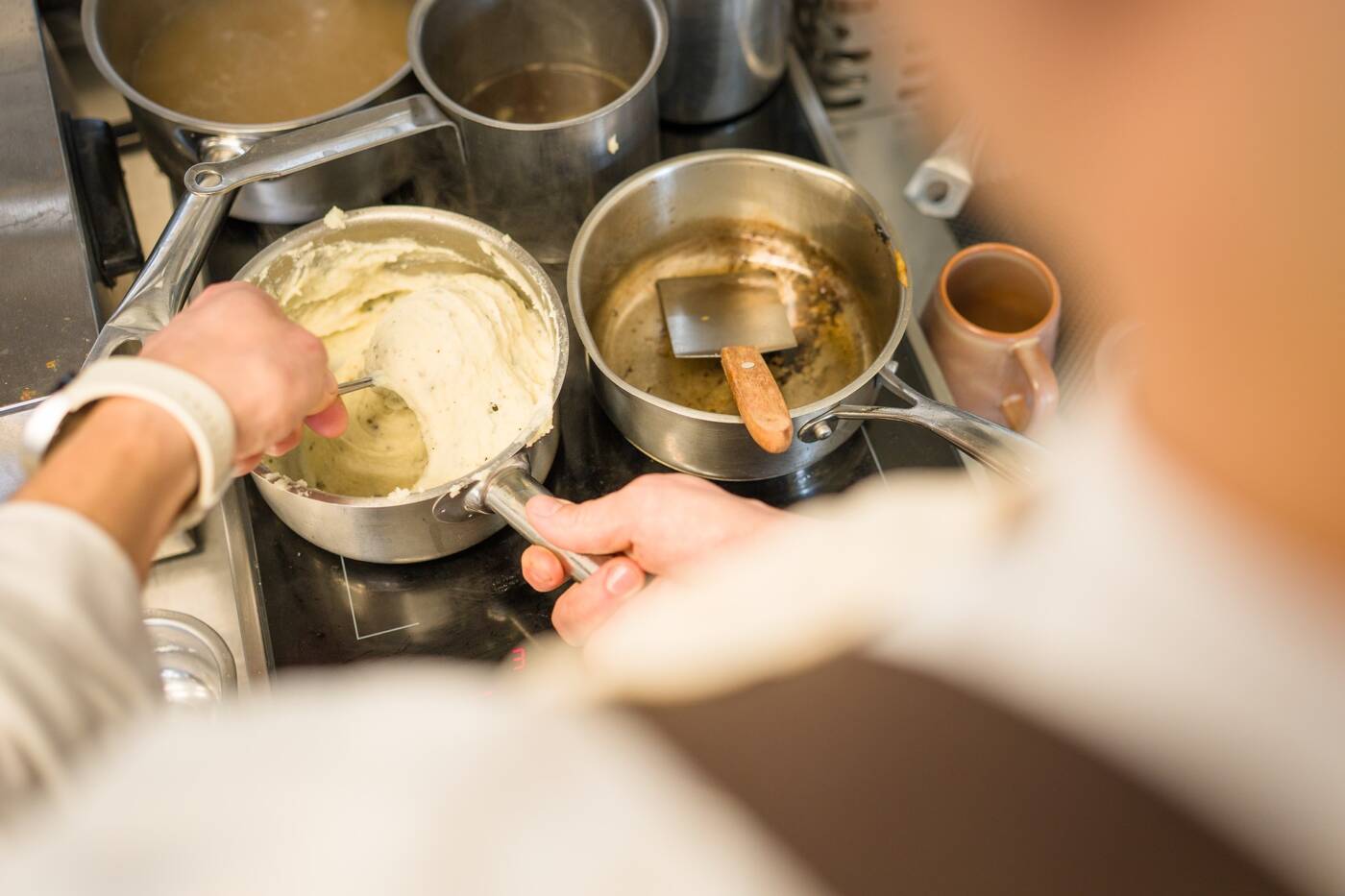 zoom sur les mains de Simon De Ramecourt en train de préparer un plat dans son restaurant la Tablée
