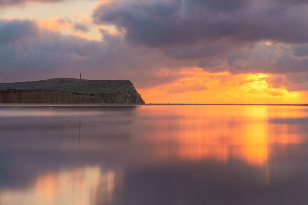 La plage au pied du Cap Blanc Nez au soleil Couchant orangé.