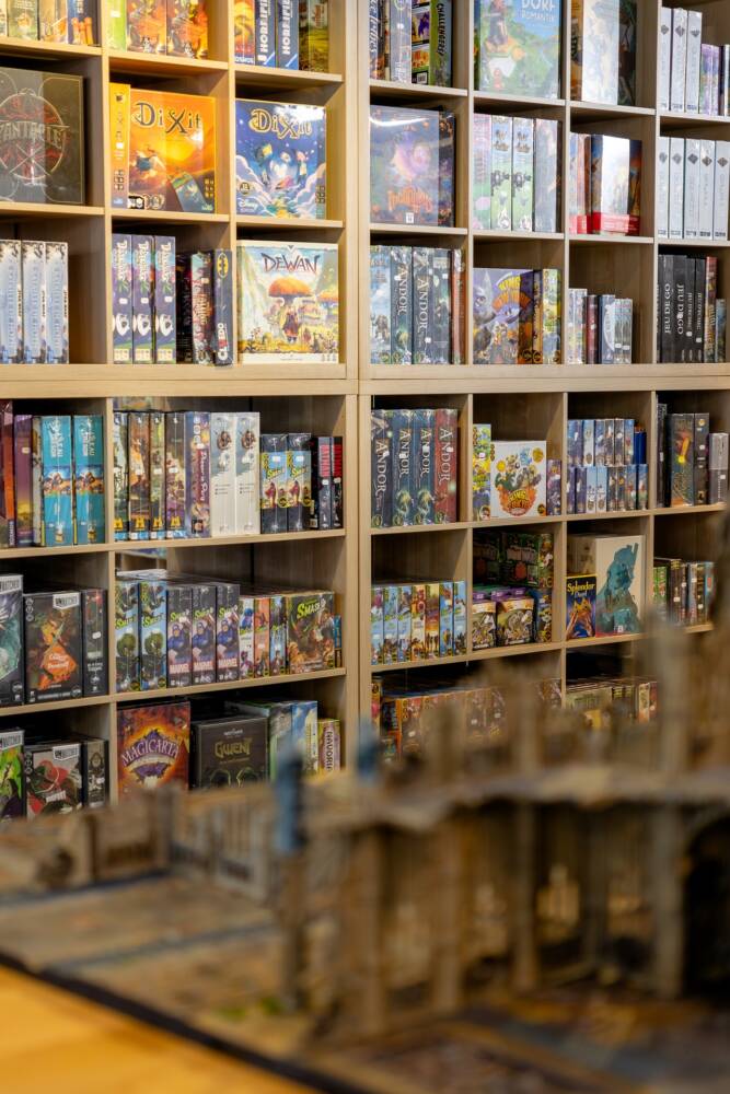 Een muur vol bordspellen te koop in de Caverne du Jeu.