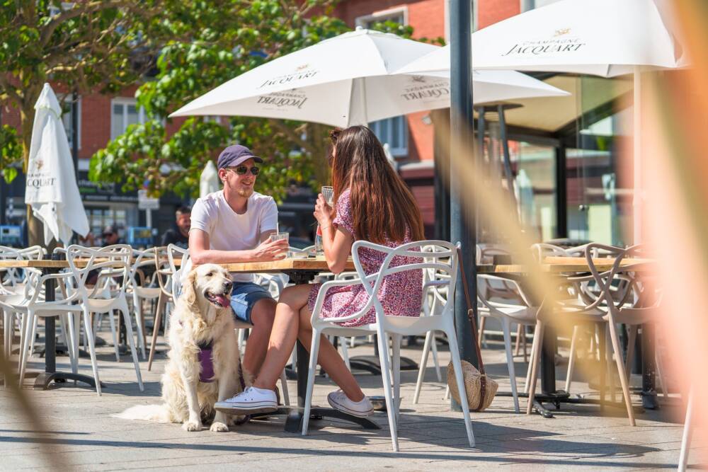 Couple profitant du beau temps pour prendre un verre en terrasse d'un bar à Calais Nord