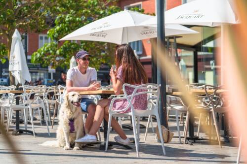 Couple profitant du beau temps pour prendre un verre en terrasse d'un bar à Calais Nord
