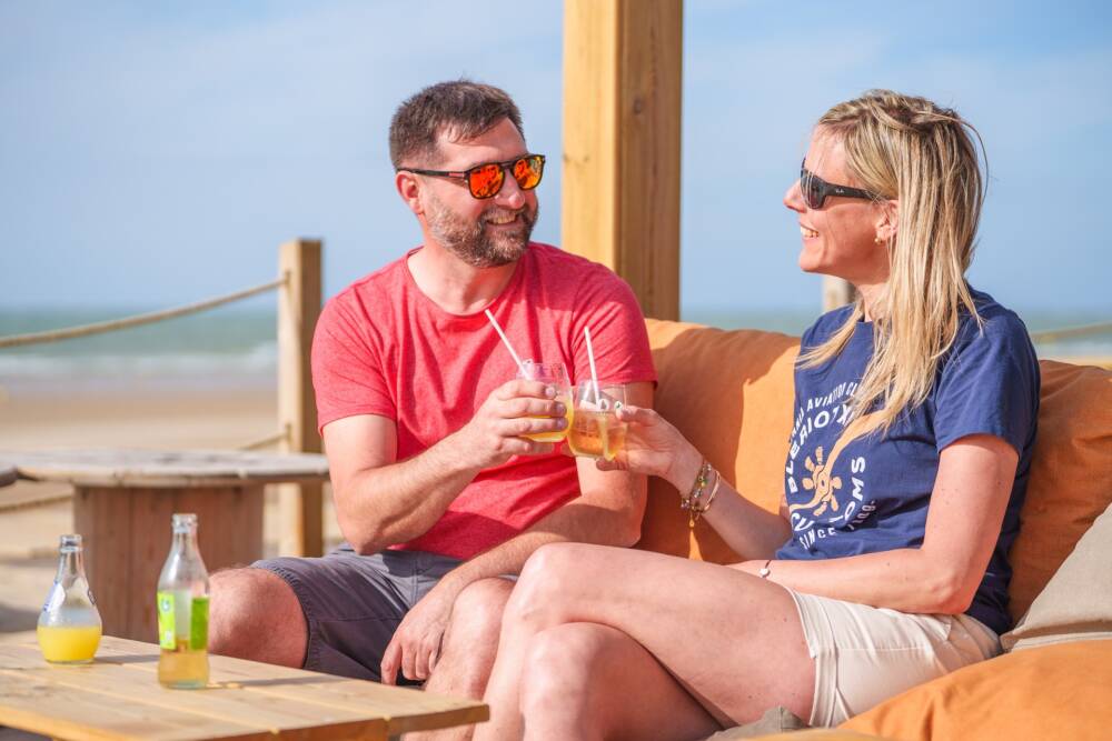 Couple en terrasse sur le bar de plage l'Aviateur avec la mer en arrière plan.