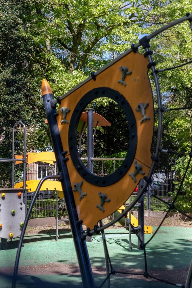 Aire de jeux sécurisée du parc Richelieu de Calais, entourée de verdure